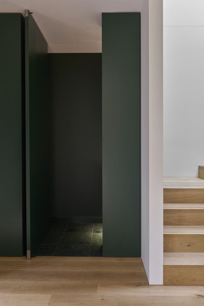 Green full height concealed door into the powder room.