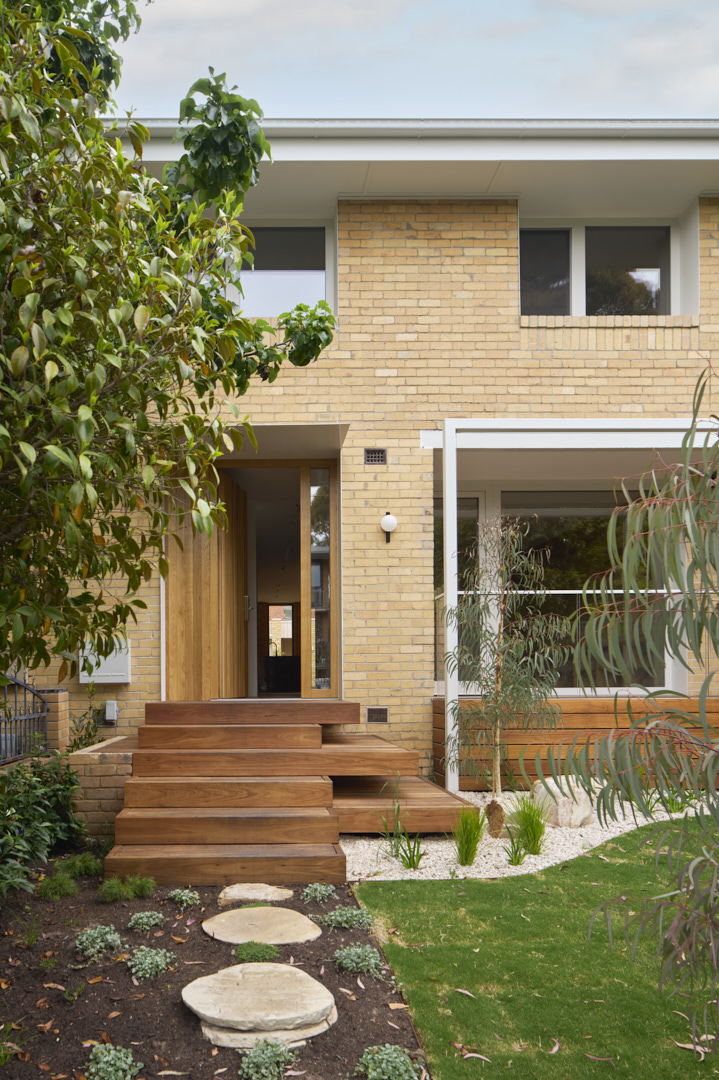 Front facade of Fitzroy Passivhaus with pale brickwork and recessed entry courtyard.