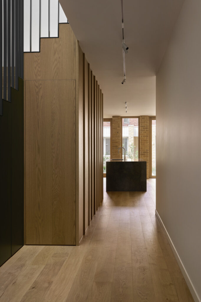 Timber-lined corridor leading to open-plan kitchen area.