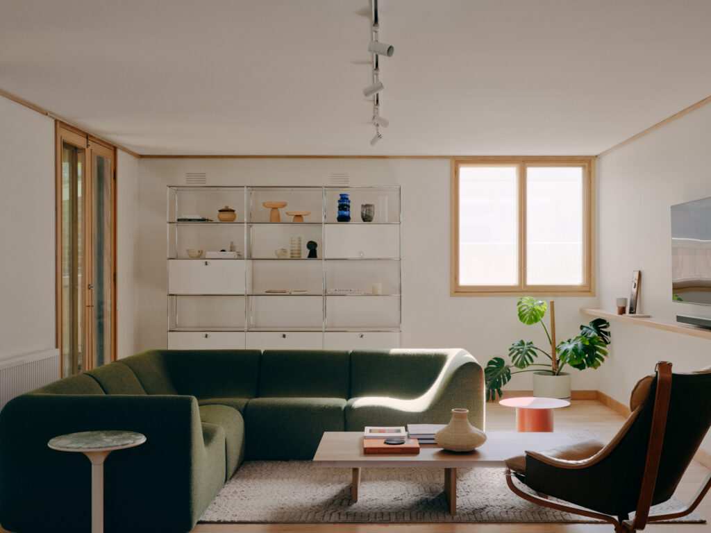 Mid-century inspired living room with green sofa and built-in shelving in Ivanhoe renovation.
